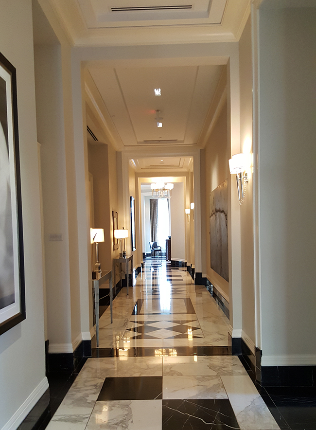 An elegant marble hallway flanked by modern art near the lobby area at Mandarin Oriental Atlanta.